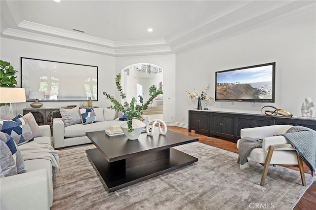 living room featuring a tray ceiling and light wood-type flooring