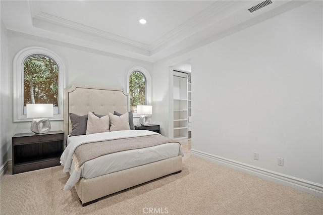 carpeted bedroom featuring crown molding, a tray ceiling, and multiple windows