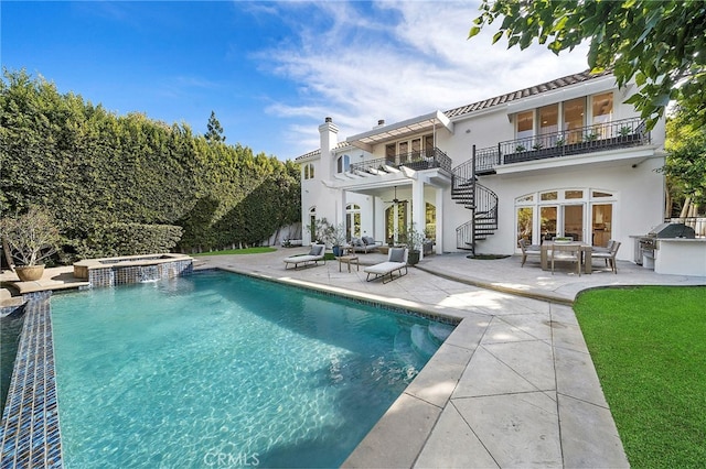 exterior space with a patio area, an in ground hot tub, and an outdoor hangout area