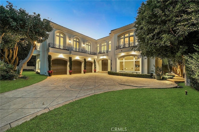 mediterranean / spanish-style house with a balcony, a front yard, and a garage