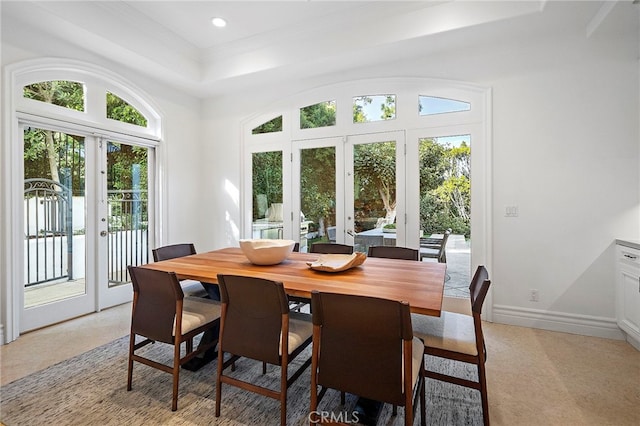 dining room with a raised ceiling and french doors