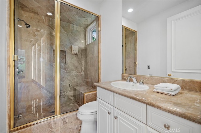 bathroom featuring an enclosed shower, vanity, and toilet