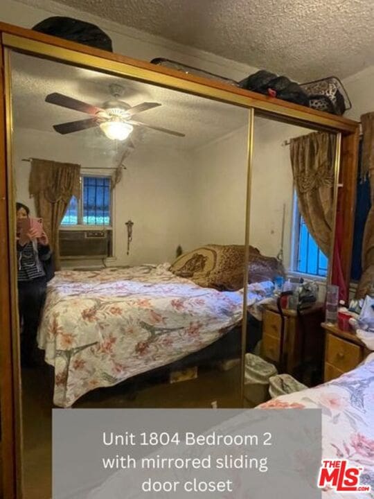 bedroom with a closet, a textured ceiling, and ceiling fan