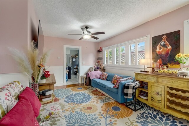 living room with a textured ceiling and ceiling fan