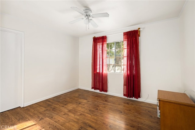 spare room with ceiling fan, crown molding, and dark wood-type flooring