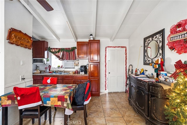 kitchen with vaulted ceiling with beams, ceiling fan, light tile floors, and sink