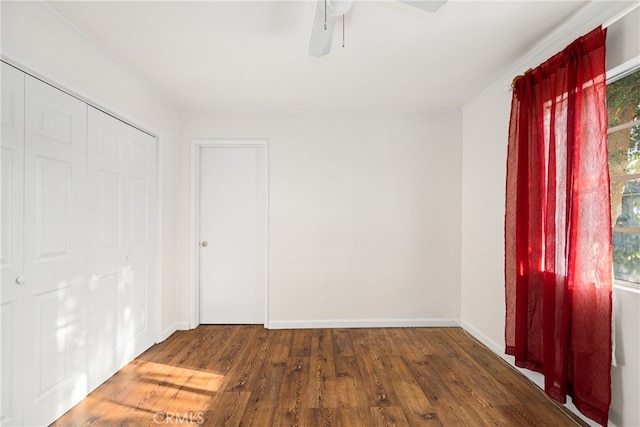 unfurnished bedroom featuring ceiling fan and dark wood-type flooring