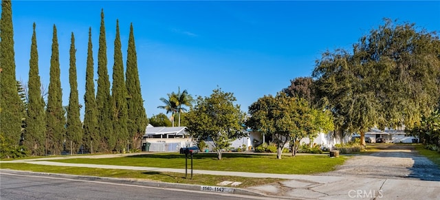 view of property hidden behind natural elements with a front lawn