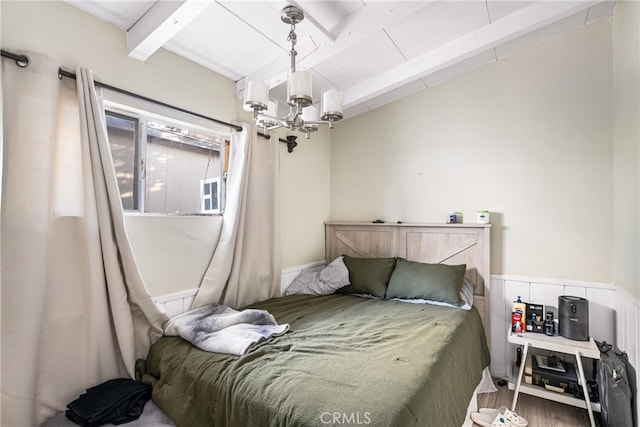 bedroom featuring beam ceiling, a chandelier, and hardwood / wood-style flooring