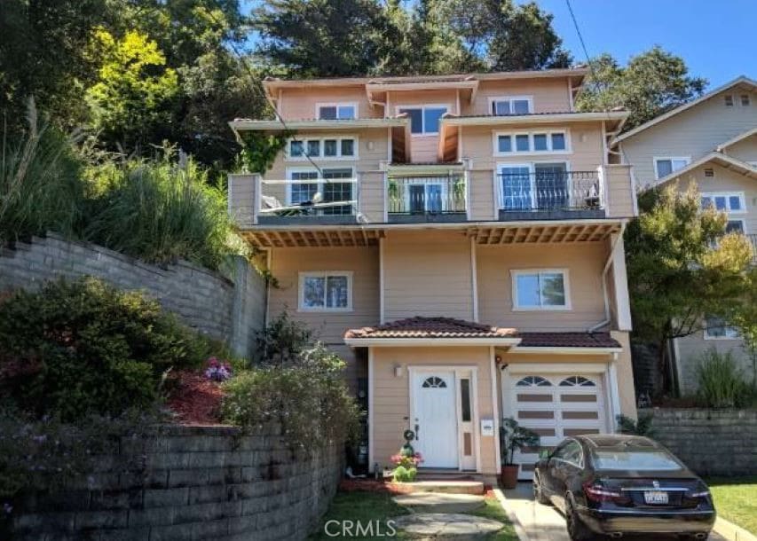 view of front of property featuring a balcony and a garage