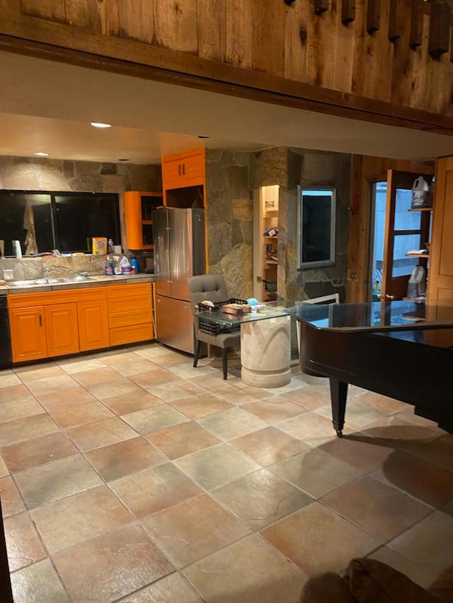 kitchen featuring black dishwasher, pool table, stainless steel fridge, sink, and light tile flooring