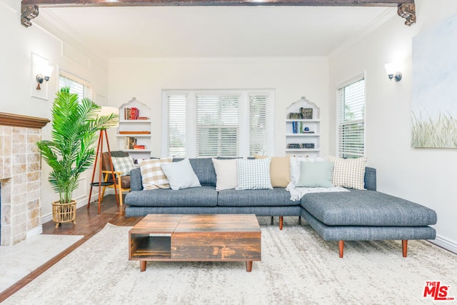 living room with a tiled fireplace, crown molding, and hardwood / wood-style flooring