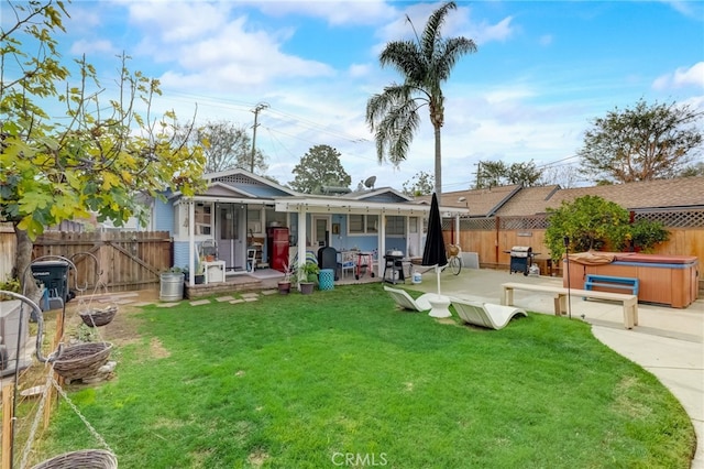 exterior space featuring a yard, a hot tub, and a patio