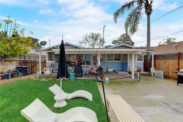 back of house featuring a patio and a lawn