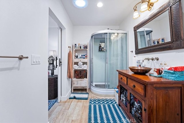 bathroom with vanity, an enclosed shower, and hardwood / wood-style floors