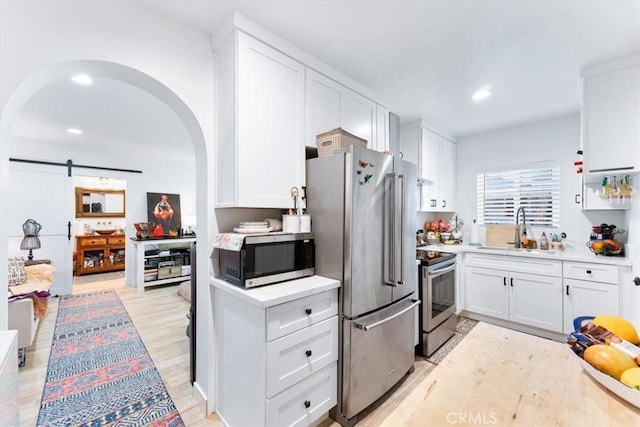 817 E Palmyra Ave, Orange, CA 92866 - kitchen with appliances with stainless steel finishes, a sink, white cabinets, arched walkways, and recessed lighting
