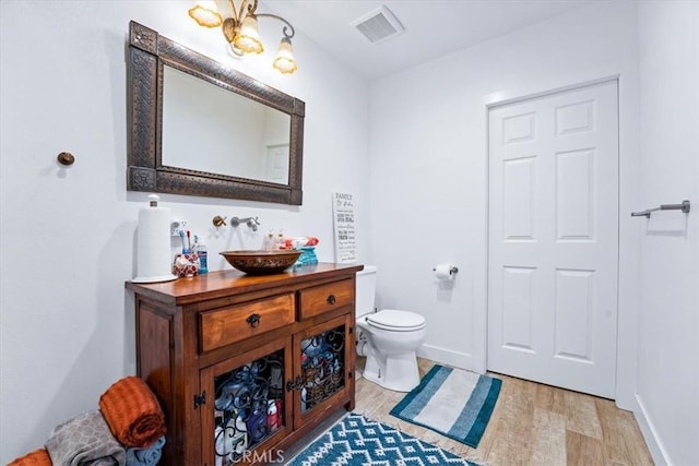 bathroom with vanity, hardwood / wood-style floors, and toilet