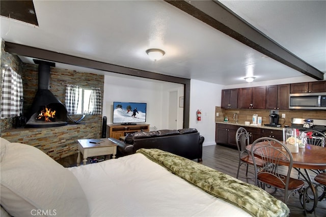 986 Cameron Dr, Big Bear Lake, CA 92315 - bedroom featuring dark hardwood / wood-style floors, beam ceiling, sink, and a wood stove