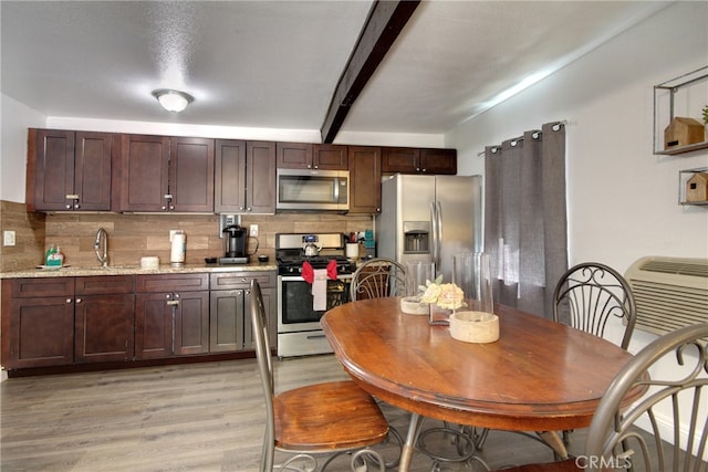 986 Cameron Dr, Big Bear Lake, CA 92315 - kitchen featuring light stone counters, beamed ceiling, light hardwood / wood-style floors, stainless steel appliances, and tasteful backsplash