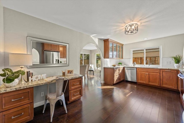 interior space with sink, stainless steel appliances, dark hardwood / wood-style floors, and light stone counters