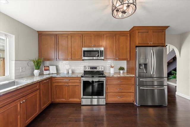 kitchen featuring a notable chandelier, dark hardwood / wood-style floors, tasteful backsplash, and stainless steel appliances