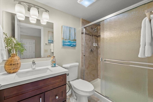 bathroom featuring tile floors, walk in shower, toilet, and vanity