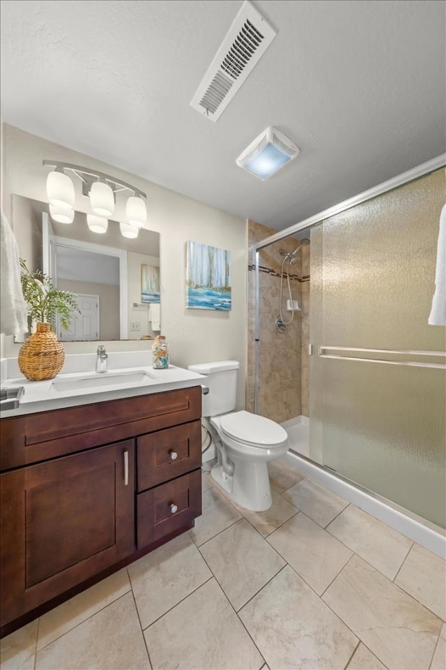 bathroom featuring an enclosed shower, vanity, tile floors, and toilet