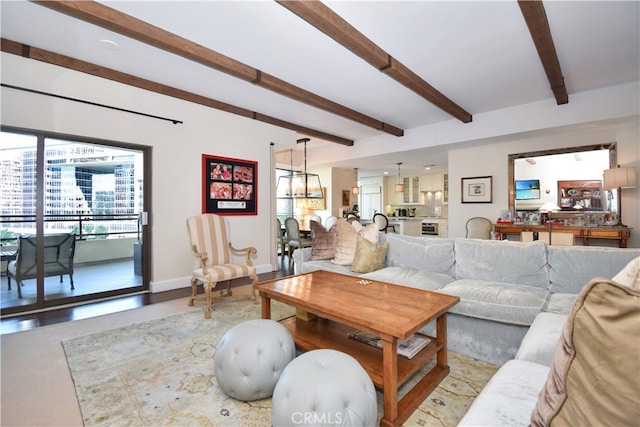 living room featuring a notable chandelier and beamed ceiling