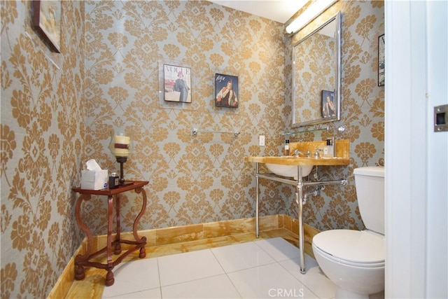 bathroom featuring toilet, tile flooring, and sink