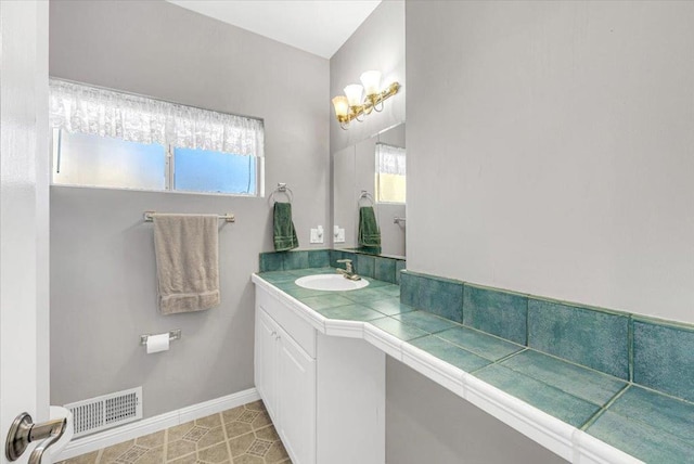 bathroom with tile patterned floors, vanity, and a healthy amount of sunlight