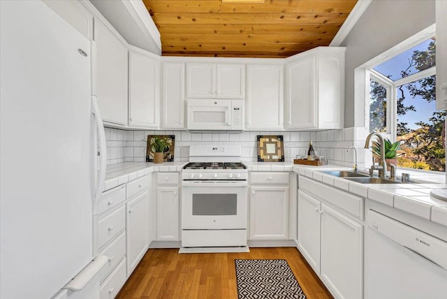 kitchen with light hardwood / wood-style flooring, white cabinetry, white appliances, and tile countertops