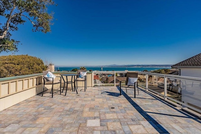 view of patio / terrace featuring a balcony and a water view