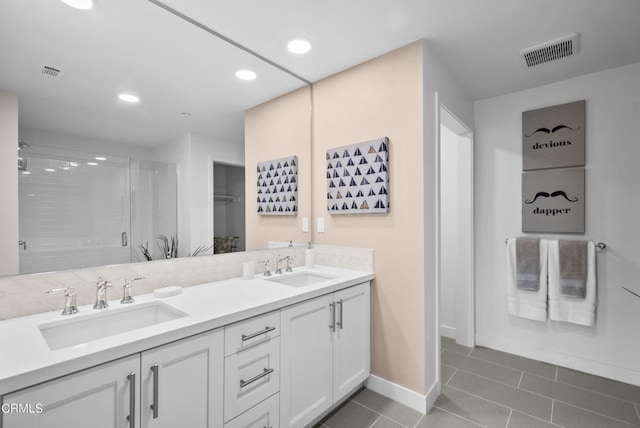 bathroom featuring dual sinks, vanity with extensive cabinet space, and tile flooring