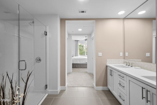 bathroom with a shower with shower door, ceiling fan, tile flooring, and vanity with extensive cabinet space
