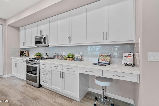kitchen featuring light hardwood / wood-style floors, tasteful backsplash, stainless steel appliances, and white cabinetry