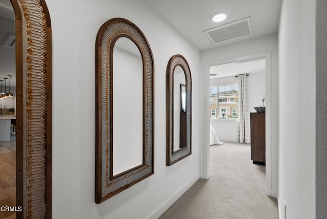 corridor featuring light colored carpet