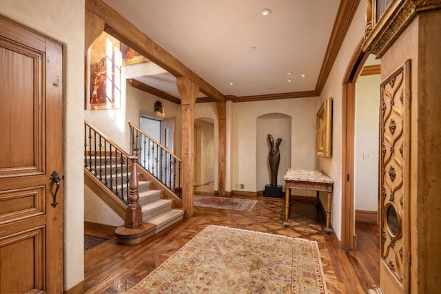 foyer entrance with crown molding and dark parquet floors