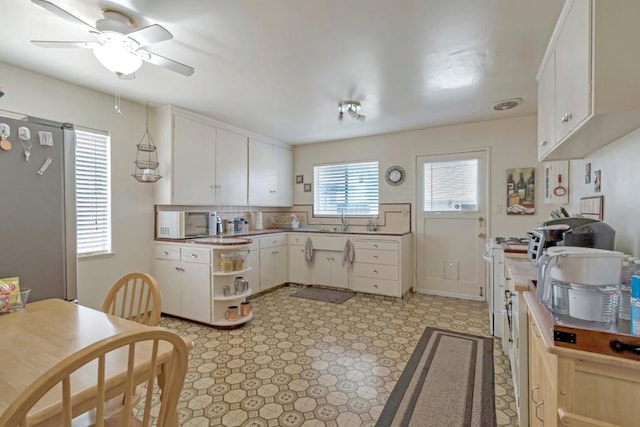 kitchen with sink, white cabinetry, ceiling fan, and light tile flooring