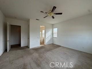 unfurnished bedroom with carpet, ceiling fan, a closet, and ensuite bath