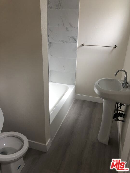 bathroom featuring hardwood / wood-style flooring, toilet, and separate shower and tub