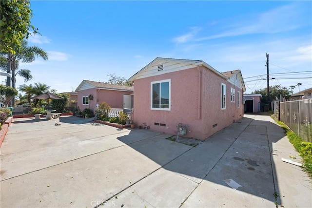 view of front facade featuring a patio area, crawl space, concrete driveway, and fence
