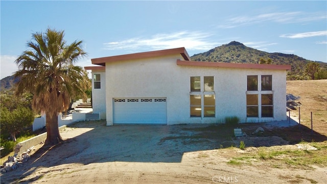 view of front of home with a mountain view and a garage