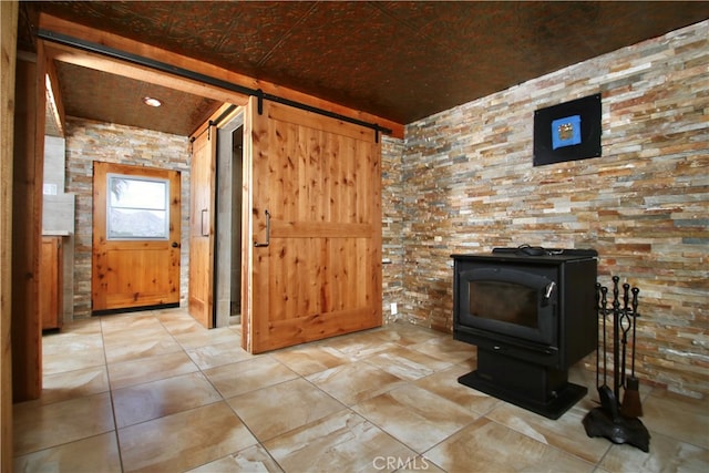 living room with a barn door and a wood stove