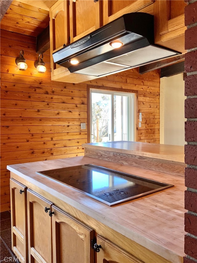 kitchen featuring wood walls, black electric cooktop, and wood ceiling