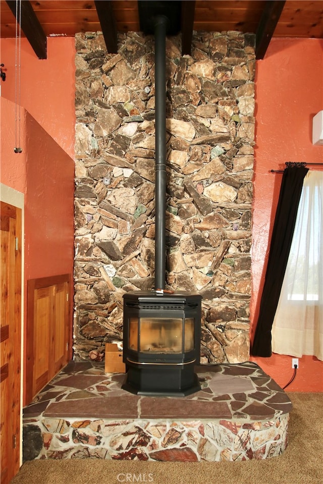 details with carpet flooring, beam ceiling, a wood stove, and wood ceiling