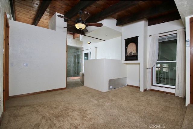 carpeted empty room with beamed ceiling, ceiling fan, and wooden ceiling