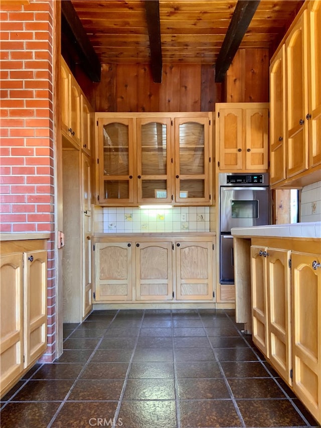 kitchen with light brown cabinets, decorative backsplash, beamed ceiling, tile counters, and wood ceiling