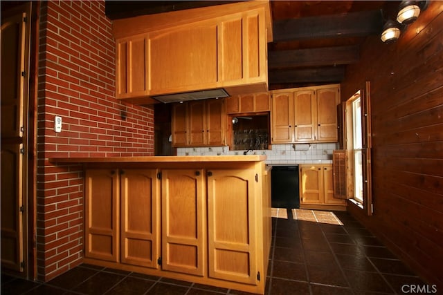 kitchen featuring dishwasher, wooden walls, dark tile patterned floors, tasteful backsplash, and beamed ceiling