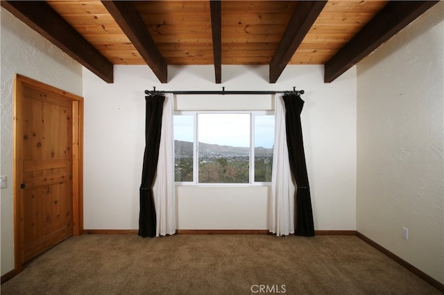 unfurnished room featuring carpet, a mountain view, beam ceiling, and wooden ceiling