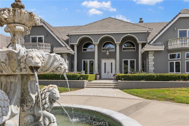 view of front of house with a balcony and french doors